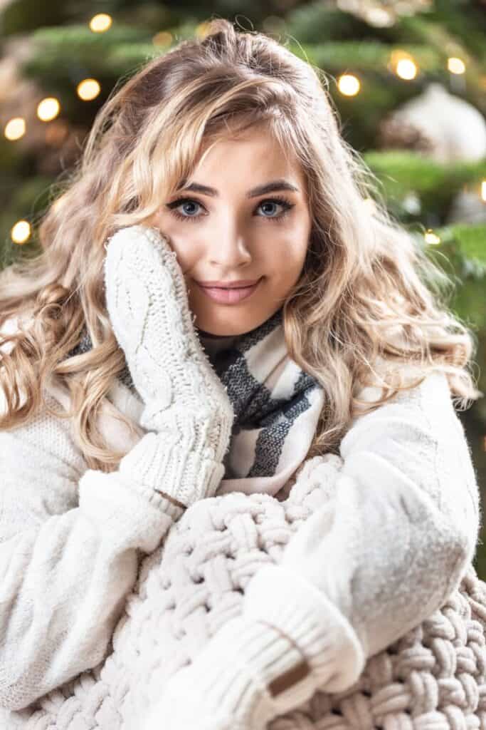 curly blonde woman in white sweather and gloves