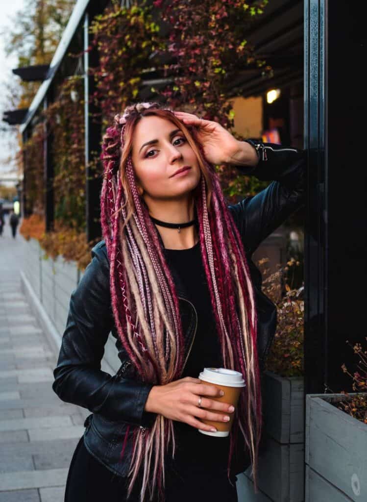 Beautiful woman with long synthetic dreadlocks in black clothes