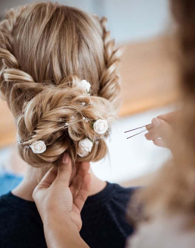 hairresser using hair pins to hold hairstyle